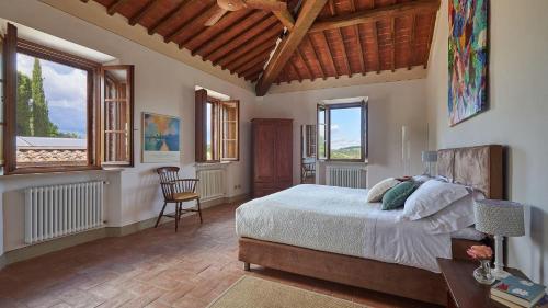 a bedroom with a bed in a room with windows at San Demetrio in Castelnuovo Berardenga