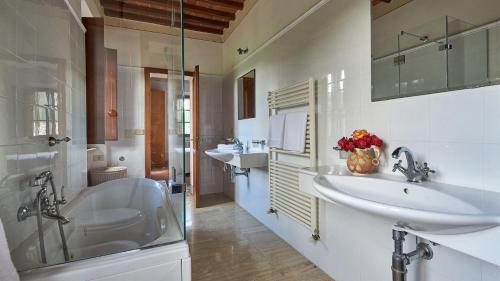 a bathroom with two sinks and a tub and a shower at San Demetrio in Castelnuovo Berardenga