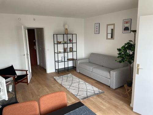 sala de estar con sofá y mesa en Studio pour 2 personnes avec Balcon Metro Marcel Sambat, en Boulogne-Billancourt