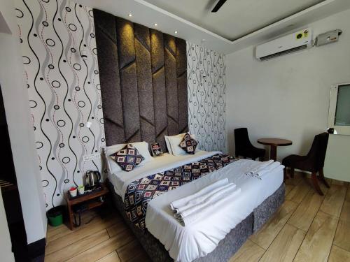 a bedroom with a bed with a large headboard at Hotel Ontario in Patiāla