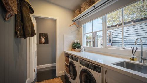 a laundry room with a sink and a washing machine at Soma Trentham in Trentham