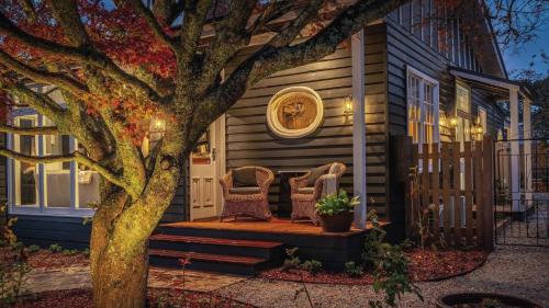 a house with two chairs and a tree at Soma Trentham in Trentham