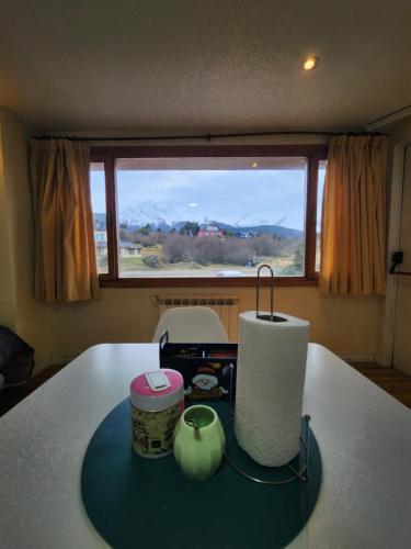 a room with a table with a large window at Mirabeagle Departamentos in Ushuaia
