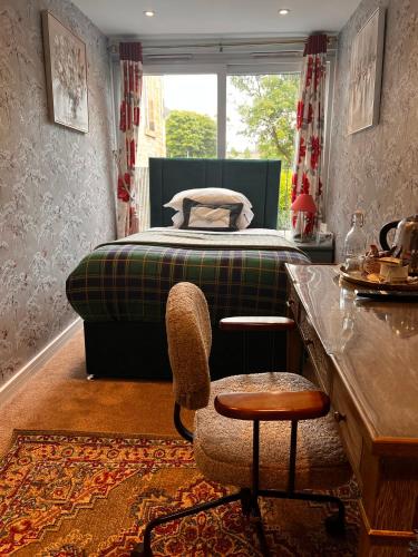 a bedroom with a bed and a chair and a table at Rosehall Hotel in Edinburgh