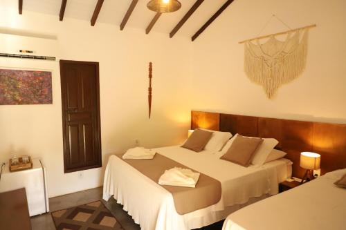 um quarto com duas camas num quarto em Pousada Estrela do Mar em Caraíva