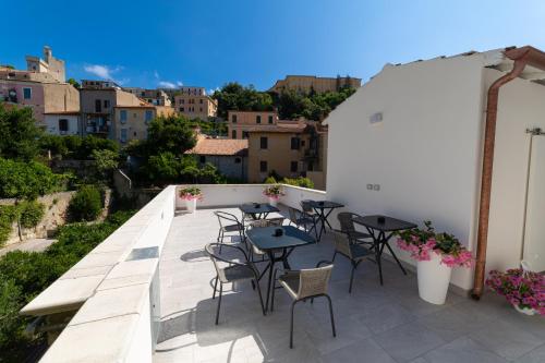 un patio con mesas y sillas en el balcón en NUMISIA Guest House en Terracina