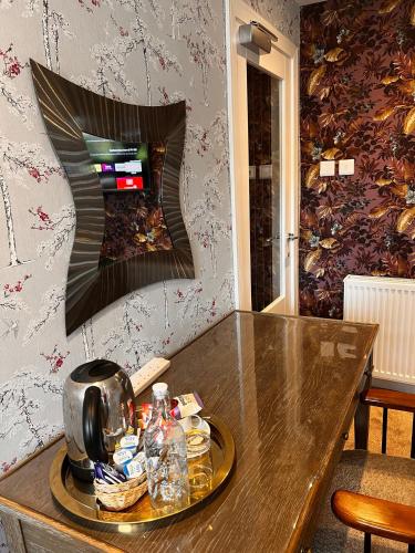 a wooden table with a tea kettle on top of it at Rosehall Hotel in Edinburgh