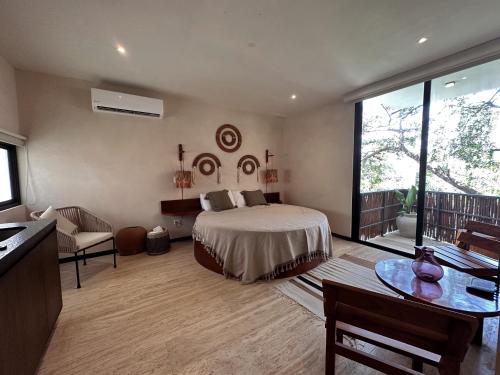 une grande chambre avec un lit et un balcon dans l'établissement Ophelia Tulum Condo Hotel in Aldea Zama, à Tulum