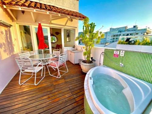 a hot tub on a deck with a table and chairs at Ipanema Duplex Penthouse in Rio de Janeiro