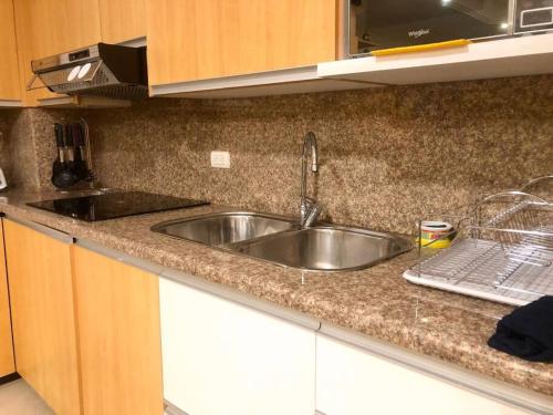 uma cozinha com um lavatório e uma bancada em Condominio La Victoria, departamento em Cuenca