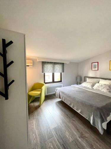 a bedroom with a large bed and a yellow chair at Holiday Home Barska Vila in Bar