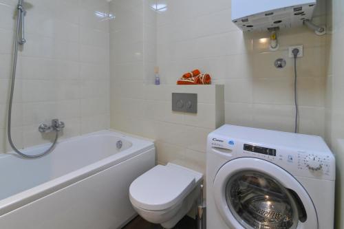 a bathroom with a washing machine and a toilet at Apartman TRSAT in Rijeka