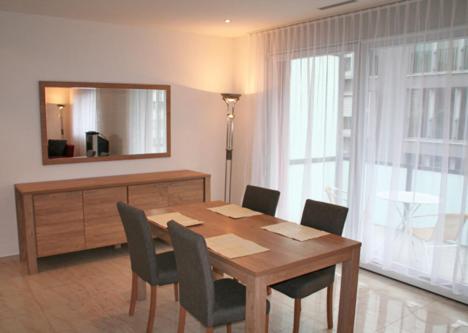a dining room table with chairs and a mirror at Nest - Bundeststrasse 6-1br in Zug