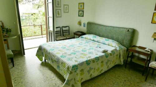 a bedroom with a bed in a room with a window at B&B Etnea Centoundici in Nicolosi