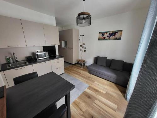 une cuisine et un salon avec un canapé et une table dans l'établissement Petit studio en plein centre-ville de Vendôme, à Vendôme