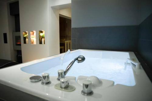 La salle de bains est pourvue d'un lavabo, d'un robinet et d'un miroir. dans l'établissement Alfa Inn, à Blankenberge