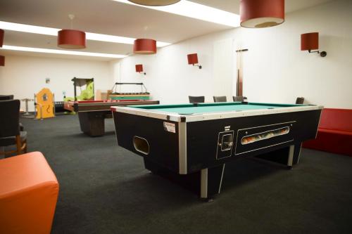 a ping pong table in a room with pool tables at Alfa Inn in Blankenberge