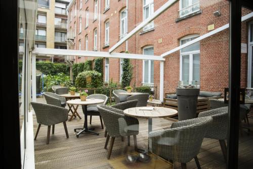 un patio avec des tables et des chaises dans un bâtiment dans l'établissement Alfa Inn, à Blankenberge