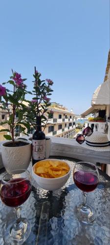 a table with two glasses of wine and a bowl of chips at Dimitra House Madouki Corfu in Mantoúkion