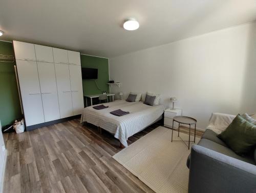 a bedroom with a bed and a couch at New studio near amenities in Nilsiä