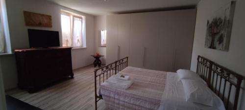 a bedroom with a bed and a flat screen tv at Appartamento Corte dei Landi in Cavriago