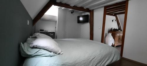 une chambre avec un lit avec des draps blancs et une fenêtre dans l'établissement appartement atypique, à Dijon