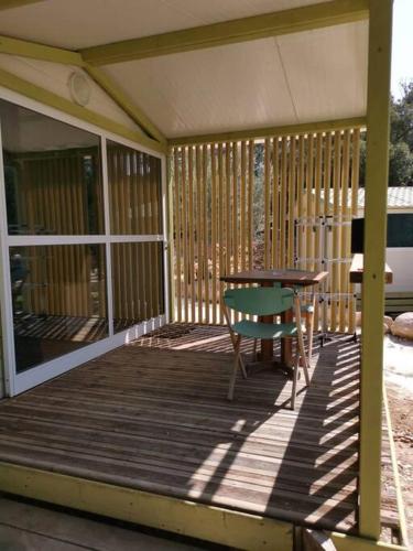 une terrasse couverte en bois avec une table et une table gmaxwell gmaxwell dans l'établissement Grande Chambre tout confort, à Bonifacio