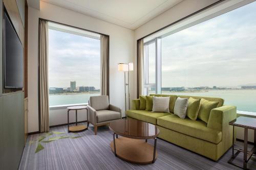 a living room with a couch and a large window at Sheraton Hong Kong Tung Chung Hotel in Hong Kong