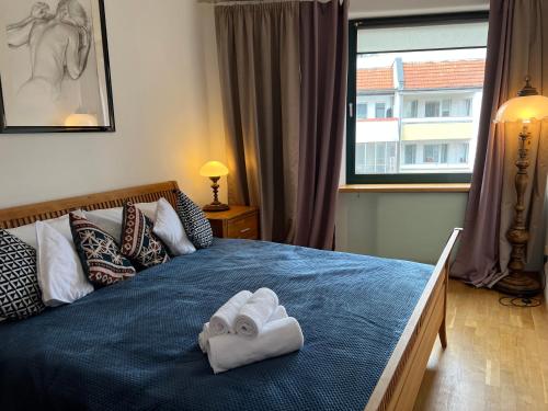 - une chambre avec un lit bleu et des serviettes dans l'établissement I&M Apartments Swiętego Mikołaja Wrocław, à Wrocław