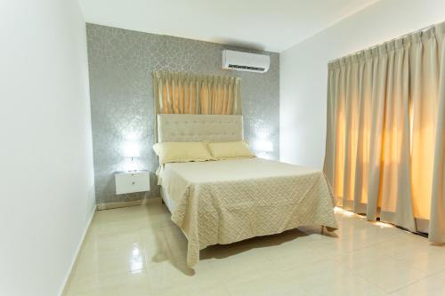 een slaapkamer met een bed in een witte kamer bij MB Apartment - A in San Felipe de Puerto Plata