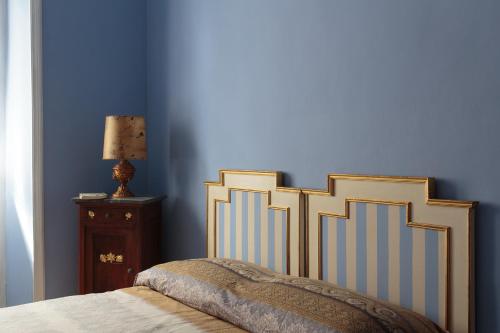 a bedroom with blue walls and a bed and a lamp at Vanchiglia Apartment - Torino in Turin