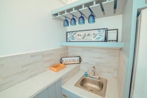 a small kitchen with a sink and a shelf at Attractive 3-Bedroom Home - Harbour Breeze in Jolly Harbour