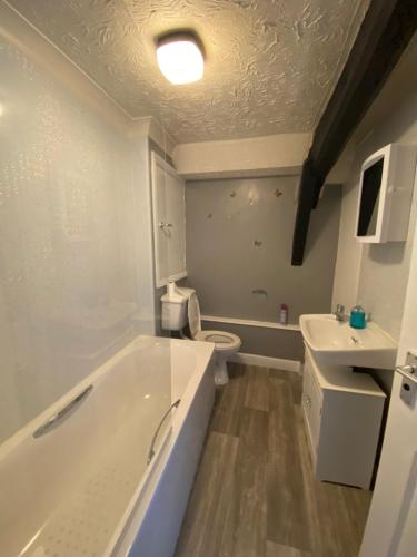 a bathroom with a tub and a toilet and a sink at Spacious One Bedroom Flat with River View, 1E in Great Yarmouth