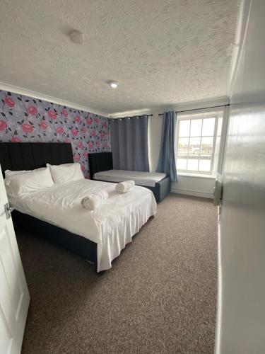 a bedroom with a large bed and a window at Spacious One Bedroom Flat with River View, 1E in Great Yarmouth