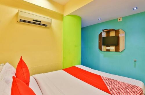 1 dormitorio con paredes verdes y coloridas y 1 cama en Hotel Honey Bunny, en Ahmedabad