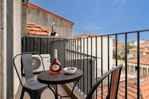 Una botella de vino sentada en una mesa en un balcón en Modern Design Duplex w/ Balcony, en Oporto