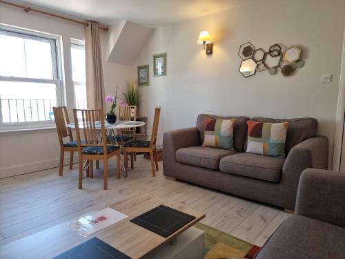 un soggiorno con divano e tavolo di Heart of Inverness-city apartment a Inverness