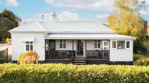 a white house with a porch at Newman House in Daylesford