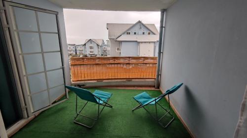 2 stoelen op een balkon met uitzicht bij Appartement Moderne & Chaleureux in Le Tampon