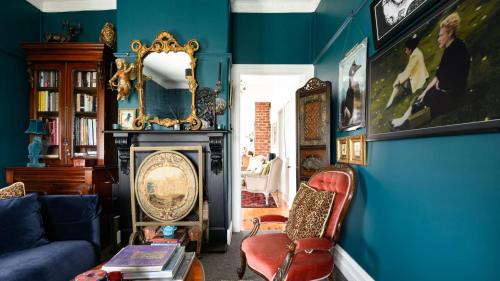 a blue living room with a couch and a fireplace at Newman House in Daylesford