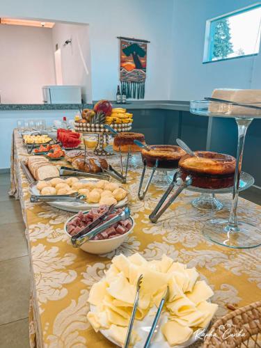 a table with many different types of food on it at Pousada Dona Tereza in Guapé