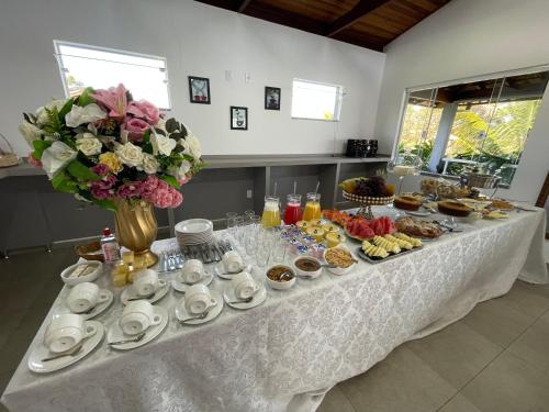 a table with a buffet of food and flowers at Pousada Dona Tereza in Guapé