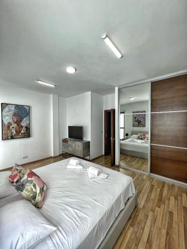 a bedroom with a large white bed and a bathroom at Charming House in the Heart of Limassol in Limassol