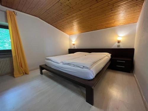 a bedroom with a bed with a wooden ceiling at Casa Karin in Canazei