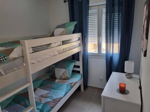 sypialnia z łóżkiem piętrowym, biurkiem i oknem w obiekcie maison cosy avec petit jardin w Awinionie