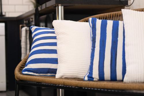 Duas almofadas azuis e brancas numa cadeira de vime em No5a, Studio Apartment, Willowbrook House em Bedworth