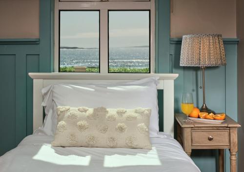 a bedroom with a bed with a pillow and two windows at Armada Cottages in Spanish Point