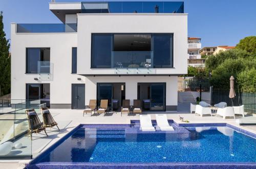 eine Villa mit einem Pool und einem Haus in der Unterkunft Villa Julian with a heated pool in Trogir