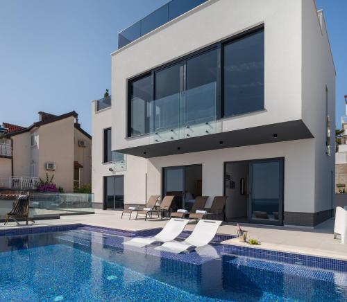 eine Villa mit einem Pool und einem Haus in der Unterkunft Villa Julian with a heated pool in Trogir