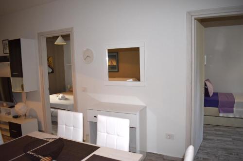Jest to biały pokój ze stołem i lustrem. w obiekcie The Sea Stars w miejscowości Nea Kallikratia